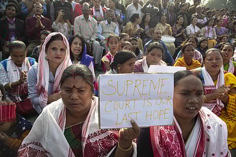 A woman holds a placard during a protest against the Citizenship Act in Gauhati on Thursday. (Photo | AP)