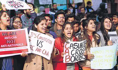 Protesters, including students and local residents, hold placards during a demonstration against the CAA outside Jamia in New Delhi. (Photo | Arun Kumar)