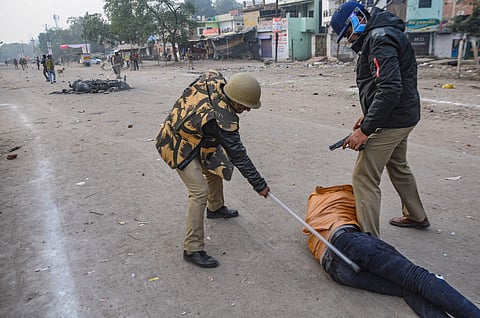 Police personnel hit a civilian during the protest against the Citizenship Amendment Act that turned violent at Babu Purwa in Kanpur Friday Dec. 20 2019. (Photo | PTI)