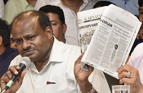 Ex-CM HDK shows a TNIE report during press meet on Mangaluru. (Photo | AEPS)