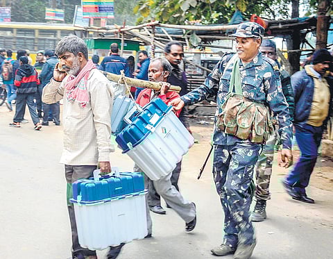 In Dhanbad, a poll staff carries EVM machines and other polling materials for of Jharkhand elections. (File | PTI Photo)