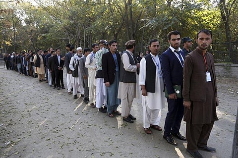 Afghan men line up to cast their votes. (Photo| AP)