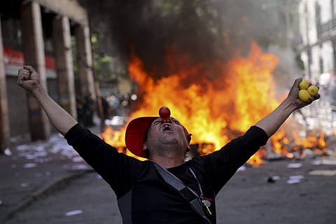An anti-government demonstrator screams in font of a burning barricade in Santiago, Chile. (Photo| AP)