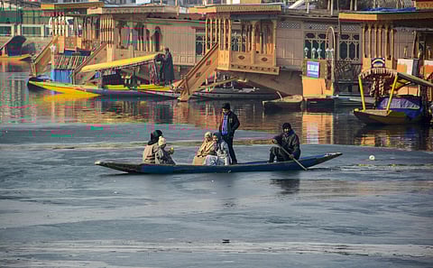 A family crosses the frozen portion of Dal Lake as temperature dips to minus 6.2 degrees Celsius in Srinagar Sunday Dec. 29 2019. (Photo | PTI)