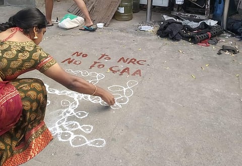 A woman drawing 'kolam' against CAA and NRC in Besant Nagar, Chennai.