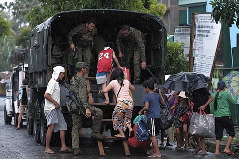 Typhoon Kammuri: Residents ride a military truck as they evacuate to safer grounds. (Photo| AP)