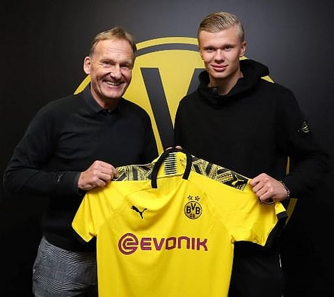 In this Handout photo made available by Borussia Dortmund shows Hans-Joachim Watzke (L), CEO of German first division Bundesliga football club Borussia Dortmund, posing with the club's new recruit, Norwegian forward Erling Braut Haaland, holding his new j