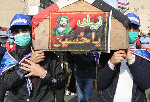 Iraqi demonstrators carry a mock coffin as they march in a symbolic funeral procession in Tahrir square in the capital Baghdad on December 8, 2019, amid ongoing anti-government protests. (Photo | AFP)
