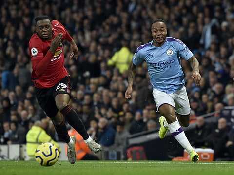 Manchester United's Aaron Wan-Bissaka, left, and Manchester City's Raheem Sterling run for the ball during the English Premier League soccer match between Manchester City and Manchester United at Etihad stadium in Manchester, England, Saturday, Dec. 7, 20