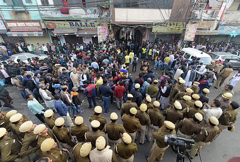 Police personnel and onlookers stand near a factory at Rani Jhansi Road. (Photo| PTI)