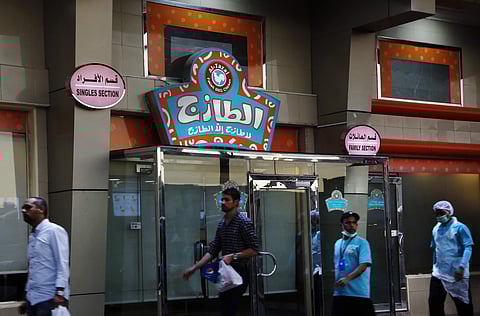 People walk in front of a restaurant with signs at top left reads, 'single section,' and at top right reads, 'family section', in Jiddah, Saudi Arabia. (Photo | AP)