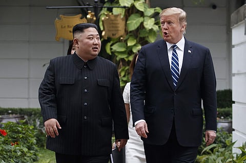 President Donald Trump and North Korean leader Kim Jong Un take a walk after their first meeting. (AP photo)