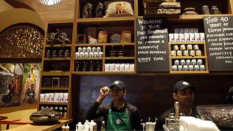 Employees at the first India outlet of Starbucks work at a counter in Mumbai. (Photo| AP)