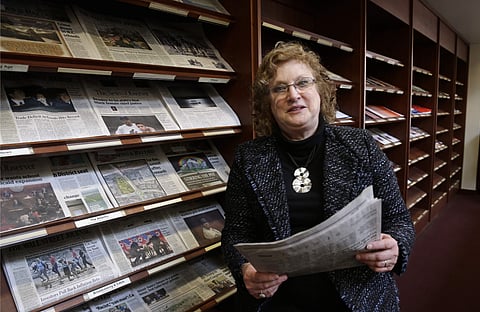 Penelope Muse Abernathy, a University of North Carolina professor, stands with the daily newspaper selection in the Park Library at the School of Journalism in Chapel Hill, N.C., on Thursday, March 7, 2019. 'Strong newspapers have been good for democracy,