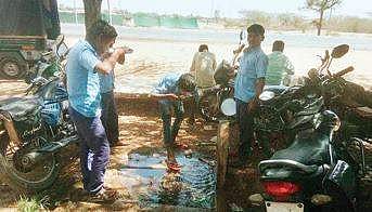 Students drinking water from the broken pipe.