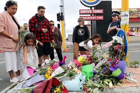 Residents place flowers at the police cordon as police conintue to search the area close by the Linwood Ave Mosque in Christchurch. (Photo | AFP)
