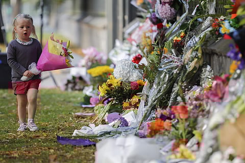 A girl walk to lay flowers on a wall at the Botanical Gardens in Christchurch, New Zealand, Sunday, March 17, 2019. (Photo: AP)