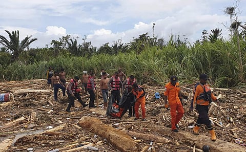 Police carry the body of flood victim at Sentani in Indonesia. (Photo| AP)