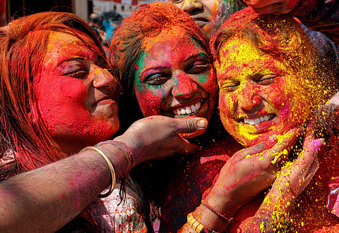 People smear colours at each other during Holi celebrations at Durgiana Temple in Amritsar. (Photo | PTI)