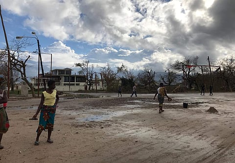 People go on their morning errands amid the shattered city of Beira, Friday, March 22 2019. Some hundreds of people are dead, many more still missing and with many thousands at risk from massive flooding in Mozambique, Malawi and Zimbabwe caused by Cyclon