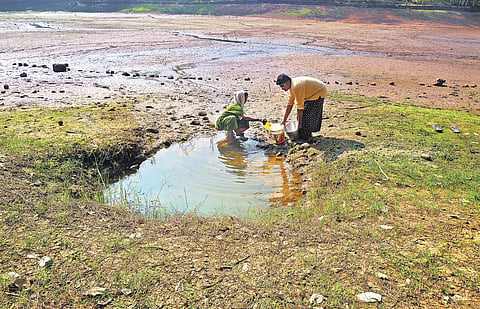 A woman helping a boy fetch drinking water at Neyyar dam Vincent Pulickal