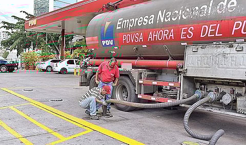 Workers unload gasoline from a fuel truck at a Petroleos de Venezuela SA (PDVSA) gas station in Caracas, Venezuela. The country has been facing fuel shortage ever since the US imposed sanctions on state-owned oil firm PDVSA to mount pressure on President 