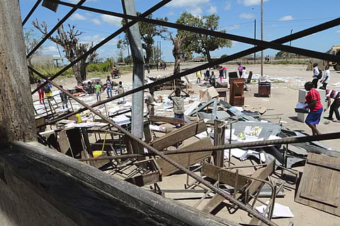 Schoolchildren pick up books that were left to dry in the sun after their school was damaged by Cyclone Idai, in Inchope Mozambique, Monday March 25, 2019. (Photo | AP)