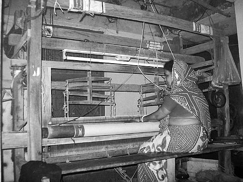 A woman busy weaving a saree at a village in Kendrapara | Express