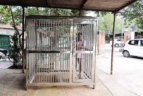 Engineer Madan Lal demonstrating a human cage designed to keep visitors safe at Delhi Zoological Park in case someone falls inside an animal enclosure, in New Delhi on Wednesday. | (Naveen Kumar | EPS)