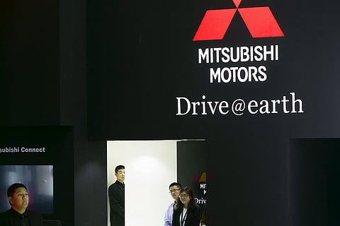 People are seen at the Mitsubishi Motors booth during the Auto China 2016 auto show in Beijing. (Photo | Reuters)