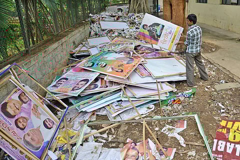 A BBMP staff at a dump place where hundreds of illegal hoardings and banners are collected at Malleshwaram BBMP office. ( File | EPS)