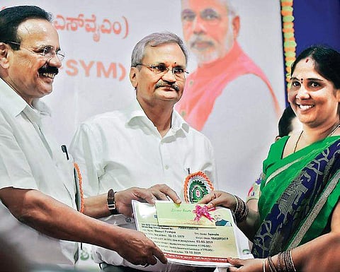 Union Minister D V Sadananda Gowda issuing a Pradhan Mantri Shram Yogi  Maan-Dhan yojana card to a beneficiary in Bengaluru on Tuesday| Pandarinath B