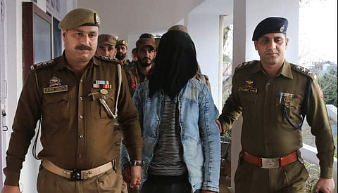 Jammu Police take away the terrorist arrested for throwing a grenade which exploded at a bus stand after a press conference in Jammu. (Photo: PTI)