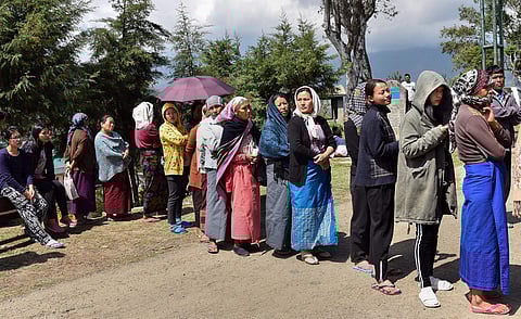 Voters standing in a queue show their ID cards before casting their votes for the Nagaland Assembly election, at a polling booth in Dimapur. 