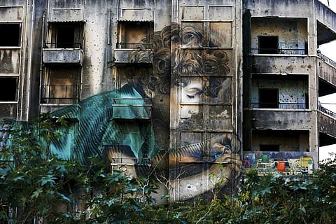 In this Nov. 12, 2018, photo, graffiti by Cuban-American artist Jorge Rodriguez-Gerada depicting a boy is painted on a bullet riddled building on the former frontline of the 1975-1990 Lebanese civil war in downtown Beirut, Lebanon. (Photo | AP)