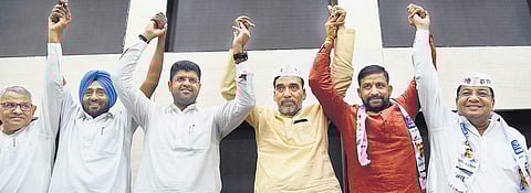 AAP leader Gopal Rai (fourth from left) and Jannayak Janata Party leader Dushyant Chautala (third from left) with their party colleagues join hands after declaring an alliance in Haryana for the Lok Sabha elections, in New Delhi on Friday. | (Parveen Negi