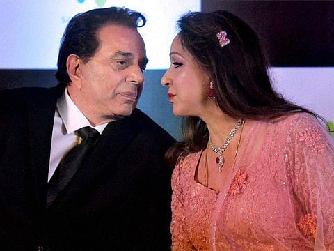 Dharmendra and Hema Malini captured in a candid moment. (PTI File Photo)