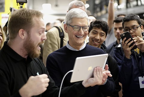 Apple CEO Tim Cook smiles as he watches a demonstration on the new iPad at an Apple educational event at Lane Technical College Prep High School in Chicago on Tuesday. (AP)