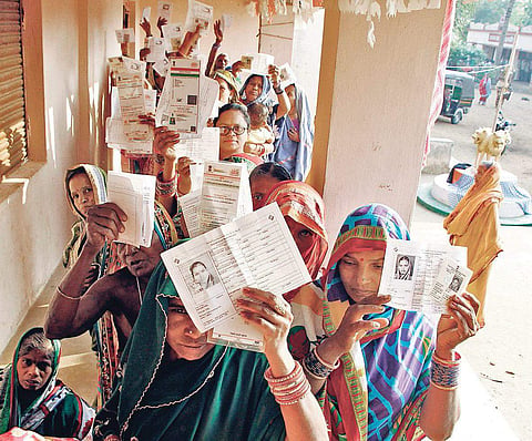 Women showing their voter ID cards at a polling booth in Ganjam district on Thursday | Express
