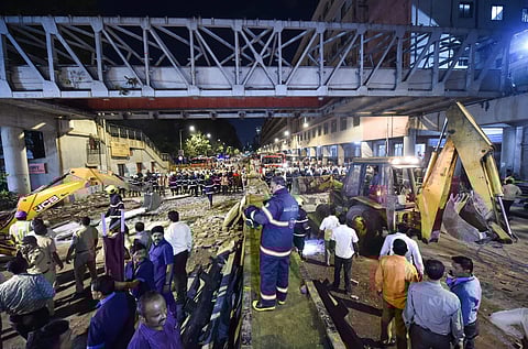 A file photo of rescue worker clear away debris of a collapsed foot overbridge in south Mumbai. (Photo | PTI)