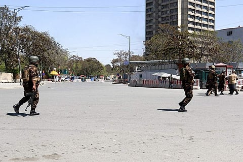 Afghan security personnel stand guard near the Afghan communication ministry as an attack between Afghan forces and attackers goes on (Photo |AFP)