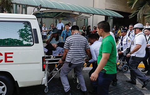 Rescue workers carry a woman to an ambulance after she became dizzy following an earthquake hit Manila, Philippines on 22 April 2019. (Photo | AP)