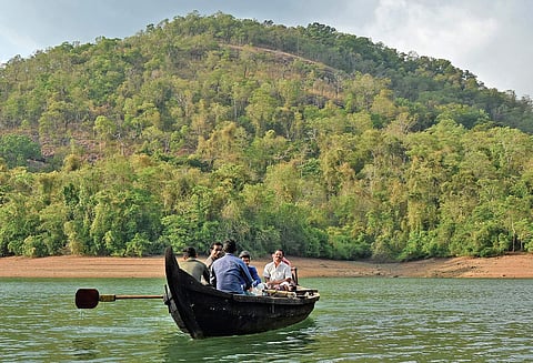 Residents of Puravimala tribal settlement near Amboori crossing Karippar river in a boat B P Deepu