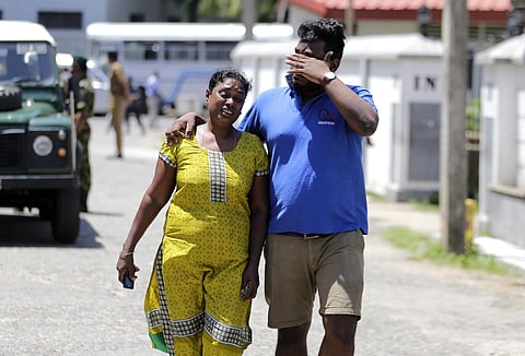 A Sri Lankan couple mourns as they leave from a mortuary after identifying the body of their relative killed in a blast, in Colombo, Sri Lanka, on 22 April, 2019. (Photo | AP)