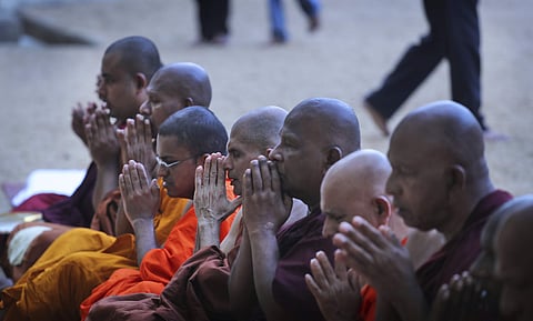 Buddhist monks pray during a ceremony to invoke blessings on the dead and wounded from Sunday's bombings at the Kelaniya temple in Colombo, Sri Lanka. (Photo | AP)