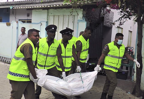 Sri Lankan policemen cover the body of an alleged terrorist after he was shot during a gunbattle in Kalmunai, in eastern Sri Lanka, on 27 April 2019. (Photo | AP)