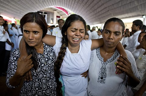 A grieving woman is supported during a funeral service attended by Cardinal Malcolm Ranjith for Easter Sunday bomb blast victims at St. Sebastian Church in Sri Lanka (Photo | AP)