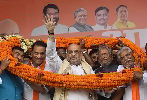 BJP chief Amit Shah being garlanded along with Bihar Deputy CM Sushil Kumar Modi and party candidate Rajiv Partap Rudy during an election rally for the Lok Sabha polls in Chhapra district of Bihar on 28 April 2019. (Photo | PTI)