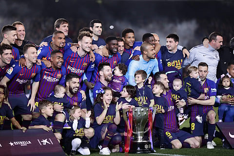 FC Barcelona players and their children pose with their trophy after winning the Spanish League title at the Camp Nou stadium (Photo | AP)