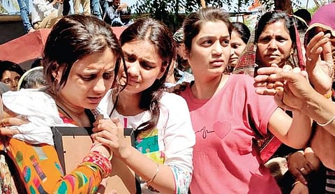Karuna Singh, wife of Lt Commander Dharmendra Singh Chauhan, hugs the portrait of her husband during his last rites at Ratlam in Madhya Pradesh on Sunday | Express